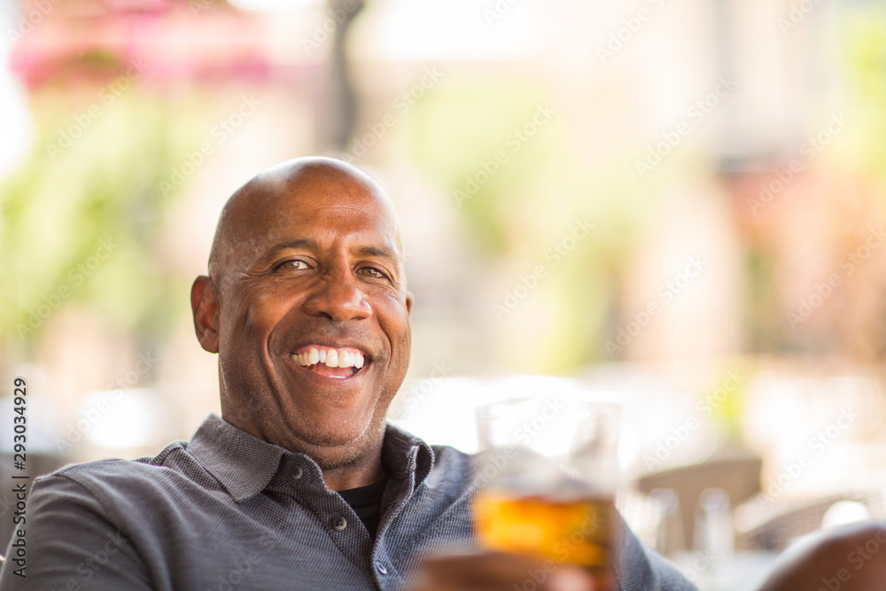 Mature African American man drinking at a restaurant.