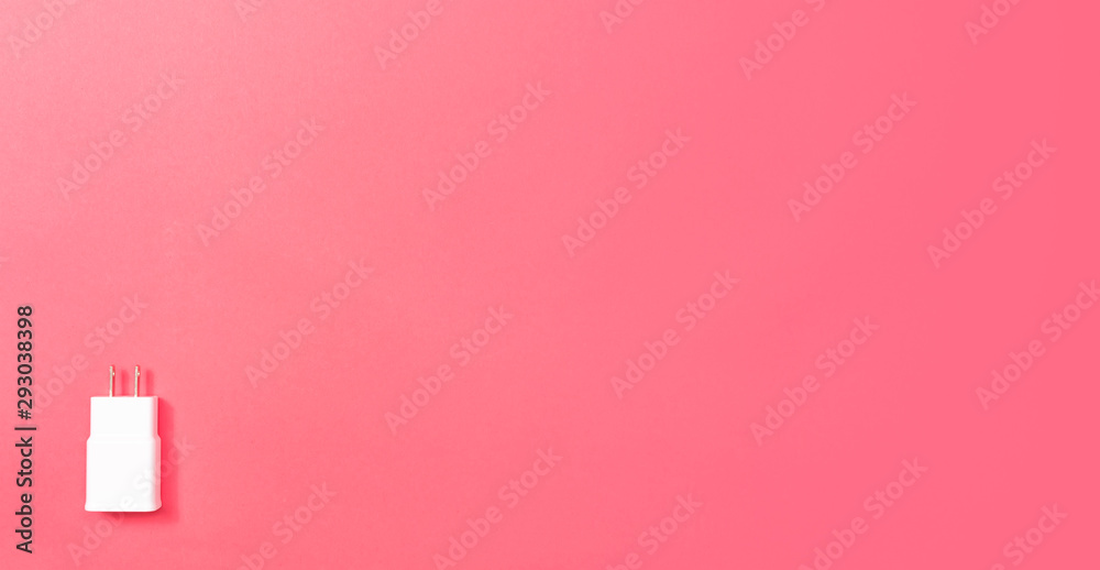 Charger plug adapter on a pink paper background