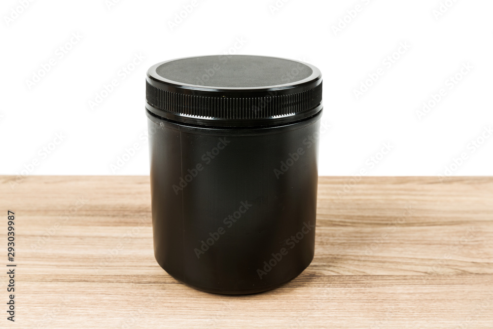 Black supplement tub on a wood patterned background Black supplement tub on a wood patterned background