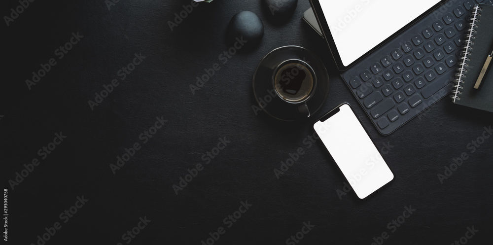 Dark modern workplace with tablet and office supplies on black leather ...