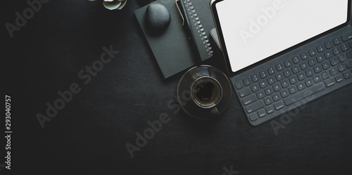 Dark trendy workplace with laptop and office supplies