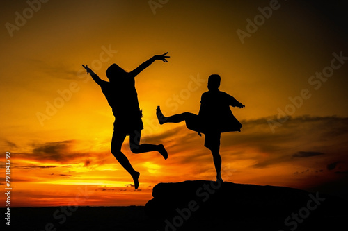  The silhouette of the man and women standing on the beach