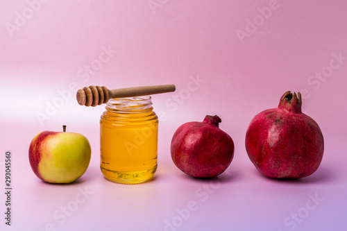 Jar of honey, apples and pomegranates on the table for the holiday of Rosh Hashanah photo