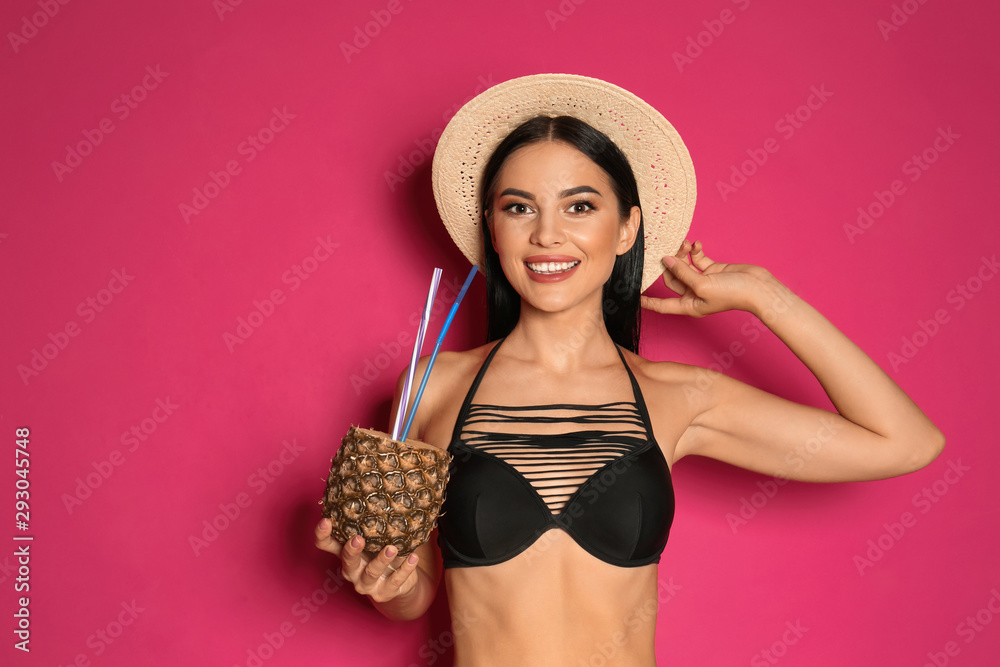 Beautiful young woman in black bikini with cocktail on pink background Beautiful young woman in black bikini with cocktail on pink background