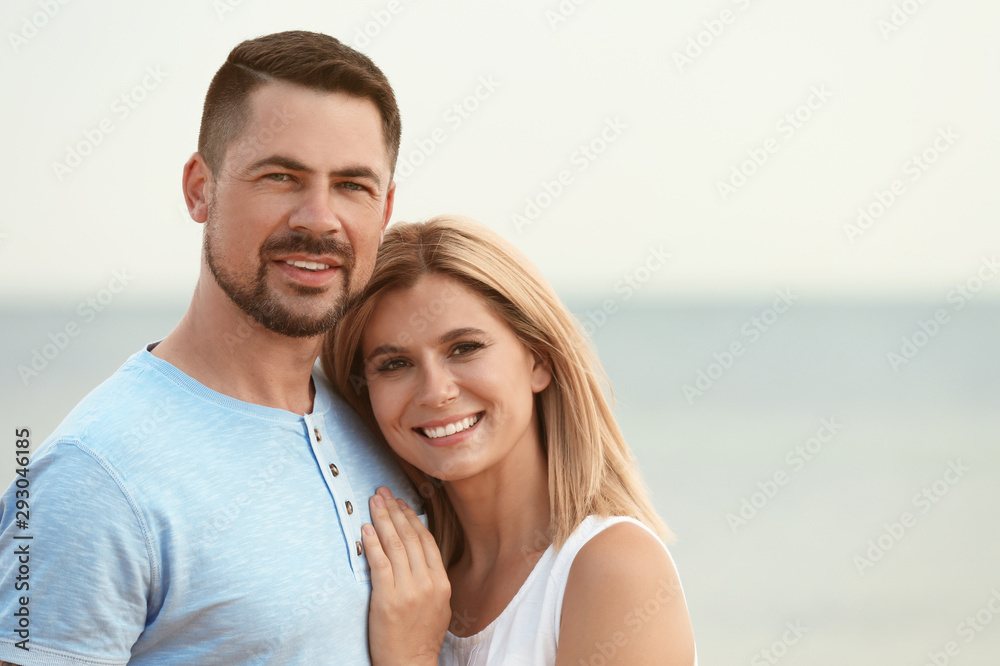 Happy romantic couple spending time together on beach, space for text