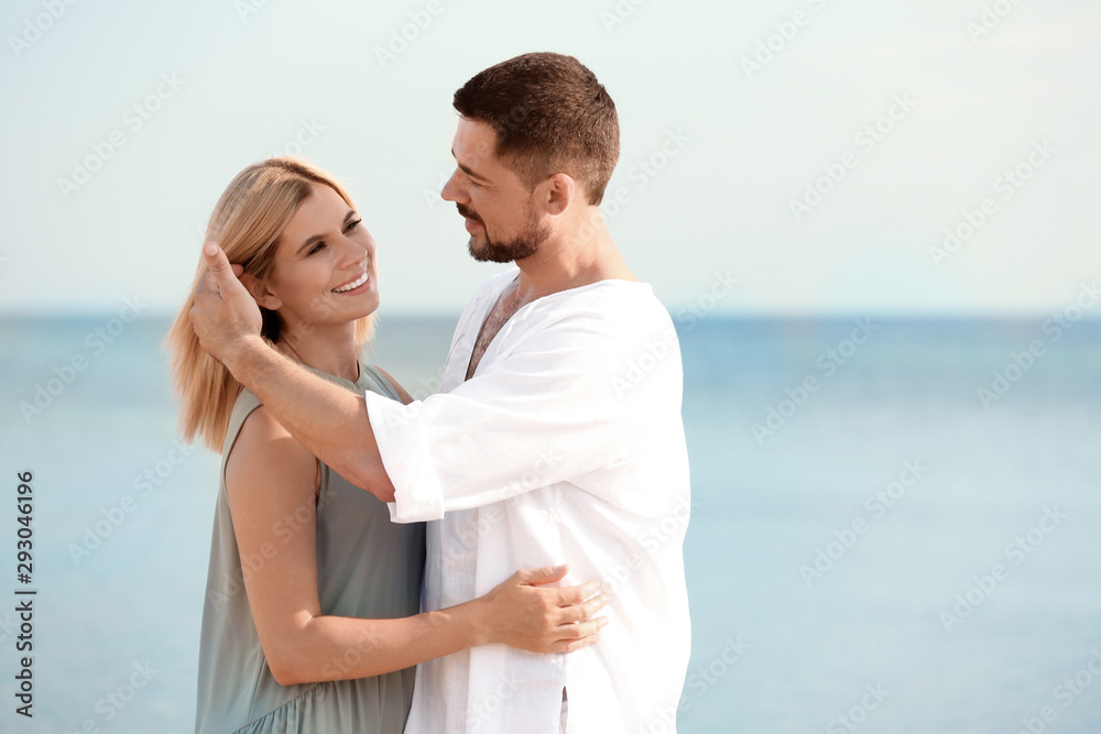 Happy romantic couple spending time together on beach