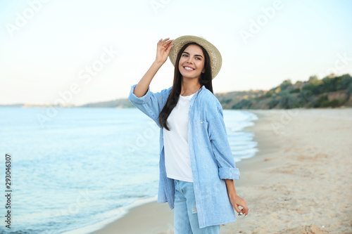 Beautiful young woman in casual outfit on beach
