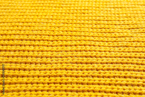 Yellow winter sweater as background, closeup view