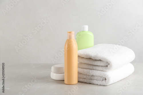 Fresh towels and toiletries on light grey marble table. Space for text