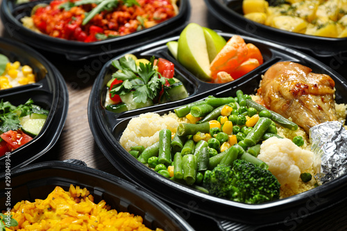 Lunchboxes with different meals on table, closeup. Healthy food delivery
