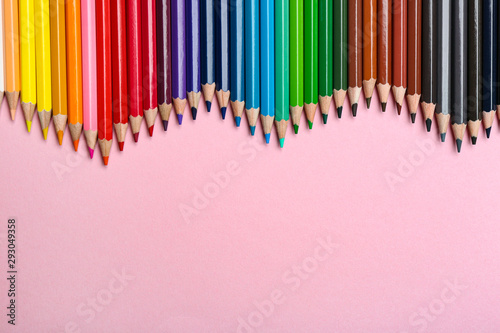 Color pencils on pink background  flat lay. Space for text
