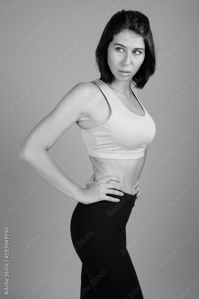 Young beautiful woman ready for gym against gray background Young beautiful woman ready for gym against gray background
