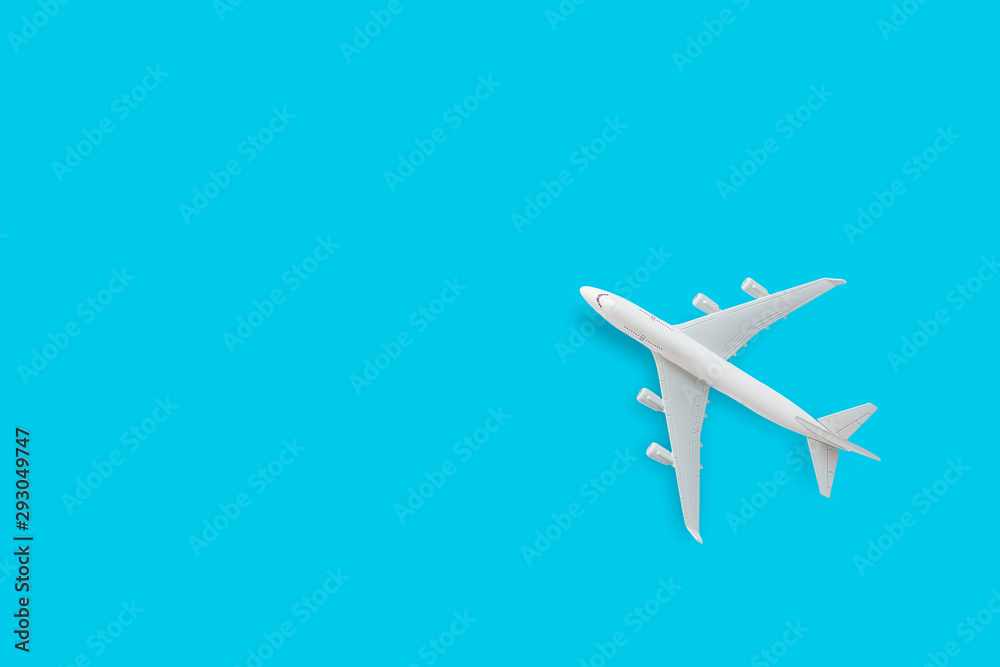 minimalist flatlay airplane flying on blue background