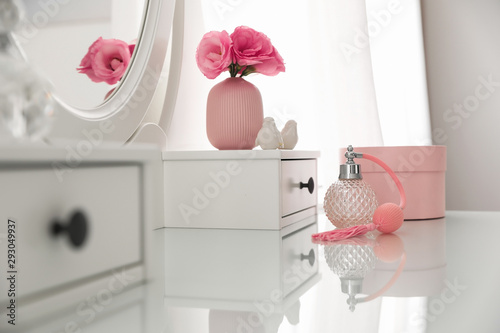 Fotografering White dressing table with decor and bottle of perfume in room