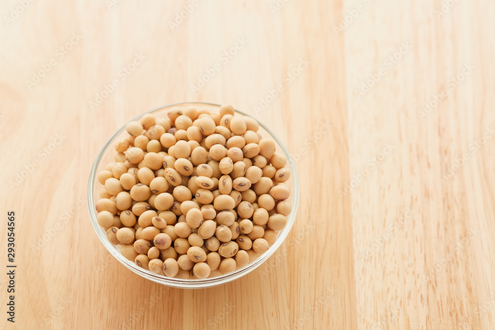 Soybeans are in a cup, placed on a wooden table with copy space,Dry bean yellow color Soybeans are in a cup, placed on a wooden table with copy space,Dry bean yellow color