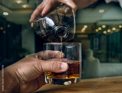 Bartender Serve Whiskey  on wood bar 