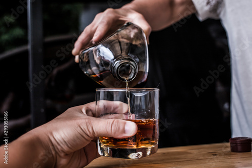 Bartender Serve Whiskey  on wood bar