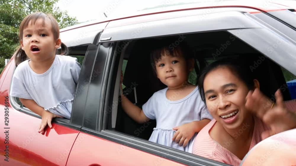 Happy Asian family sitting in a car while looking outside and preparing for travel on vacation. Happy Asian family sitting in a car while looking outside and preparing for travel on vacation.
