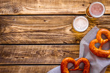 Octoberfest table background. Pretzels and beer glasses on dark wooden background top view frame space for text