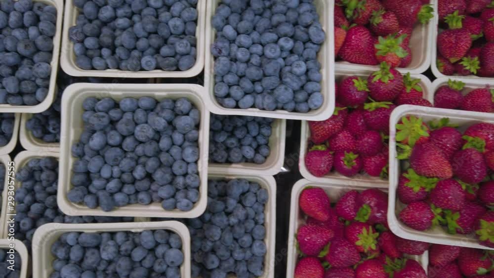 Panning topdown view of the fresh blueberry and strawberry on the shelf in supermarket- fresh fruits on the stall in Canada Panning topdown view of the fresh blueberry and strawberry on the shelf in supermarket- fresh fruits on the stall in Canada