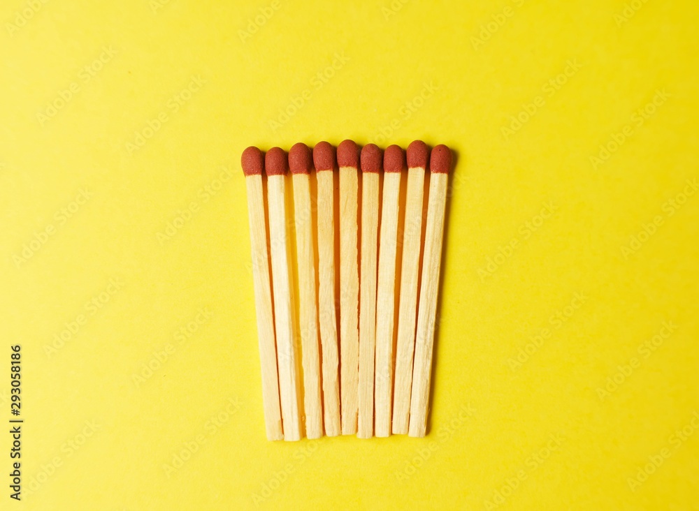 Symbol of danger with matches on yellow background top view , pile of match arrange in a row , unlit matches Symbol of danger with matches on yellow background top view , pile of match arrange in a row , unlit matches