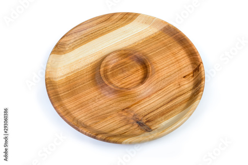 Empty round wooden serving dish with sauce boat in center