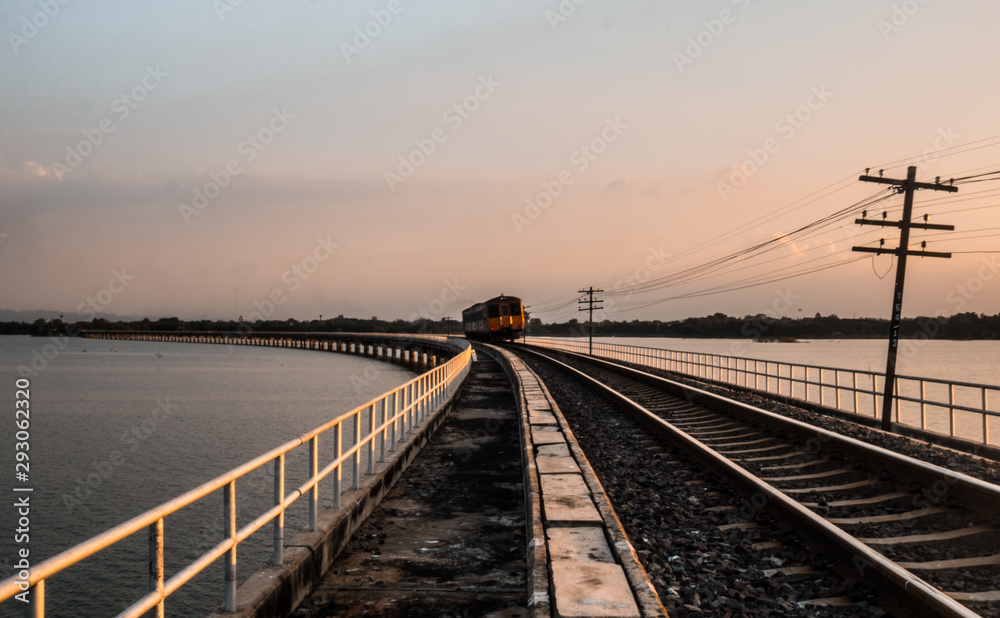  A running train on railroad tracks in dam.