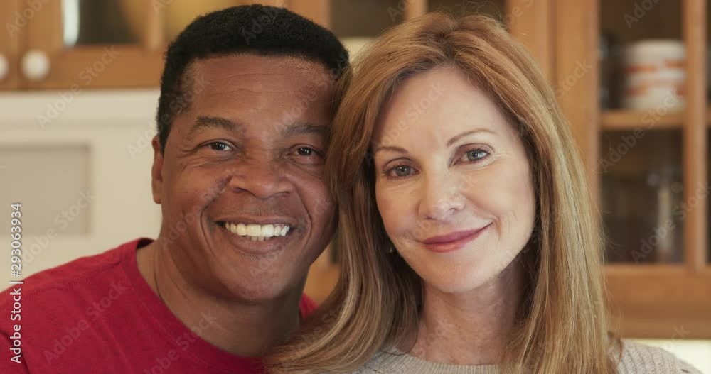 Close up dolly shot of smiling senior married couple in kitchen looking at camera. Portrait of happy African American husband and Caucasian wife together. Slow motion 4k Close up dolly shot of smiling senior married couple in kitchen looking at camera. Portrait of happy African American husband and Caucasian wife together. Slow motion 4k