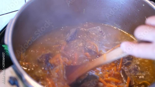 Boiling meat crots with carrots when cooking Plov traditional dish from Uzbekistan photo
