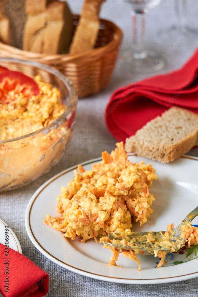 Rice salad with carrots and cheese on a white plate Rice salad with carrots and cheese on a white plate