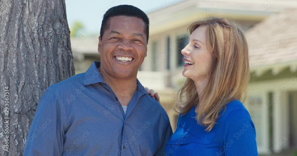 Portrait of happy older African American and Caucasian couple laughing outside on a sunny day. Smiling senior husband and wife looking at camera. Slow Motion 4k Handheld Portrait of happy older African American and Caucasian couple laughing outside on a sunny day. Smiling senior husband and wife looking at camera. Slow Motion 4k Handheld