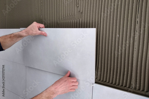 Canvas Print Worker hands putting ceramic tiles on the wall.
