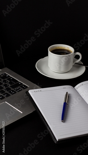 Office desk table with laptop, cup of coffee and other supplies. With copy space