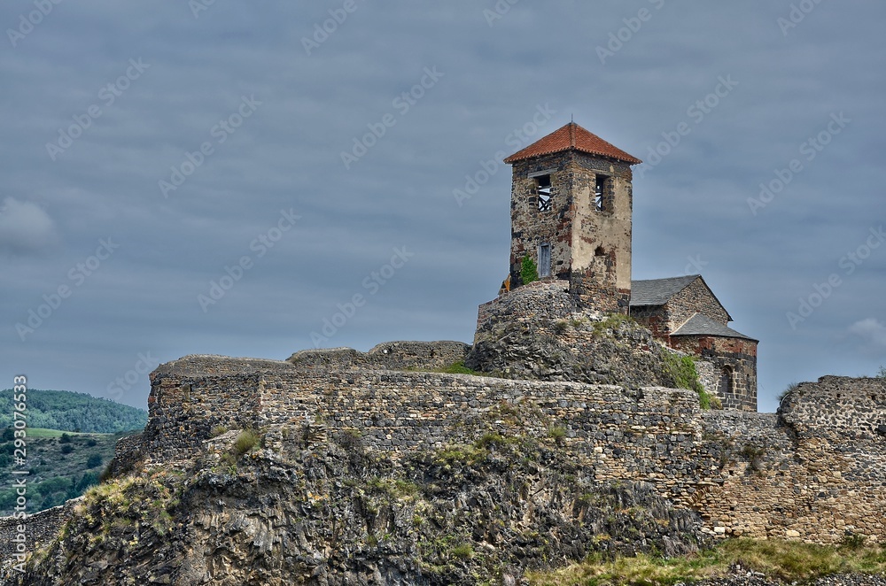 une vieille chapelle sur une colline du Massif Central. Une chapelle et des fortifications. Une église et des remparts.