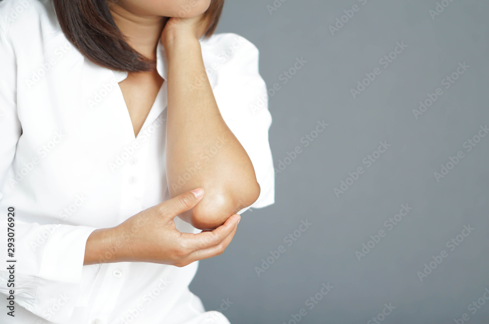 Naklejka premium Closeup woman hand holding elbow with pain lying on bed, health care and medical concept