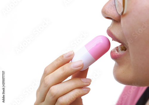 Closeup of female taking a big capsule medicine islated on white background   Drug overdose concept