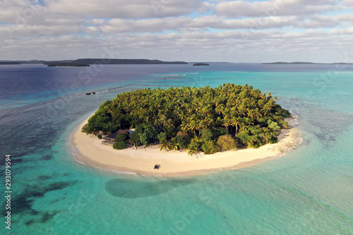 Aerial shot of a scenic landscape of desert island with white sand beach and crystal clear sea water bay. 