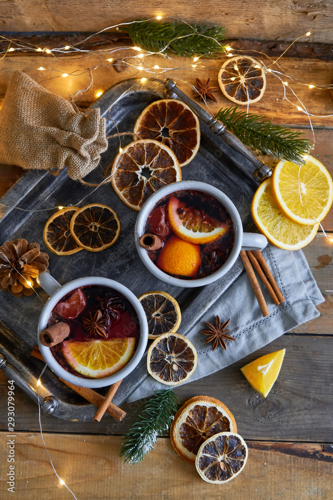 Christmas mulled wine in two rustic mugs with fruits and spices on wooden background Christmas mulled wine in two rustic mugs with fruits and spices on wooden background