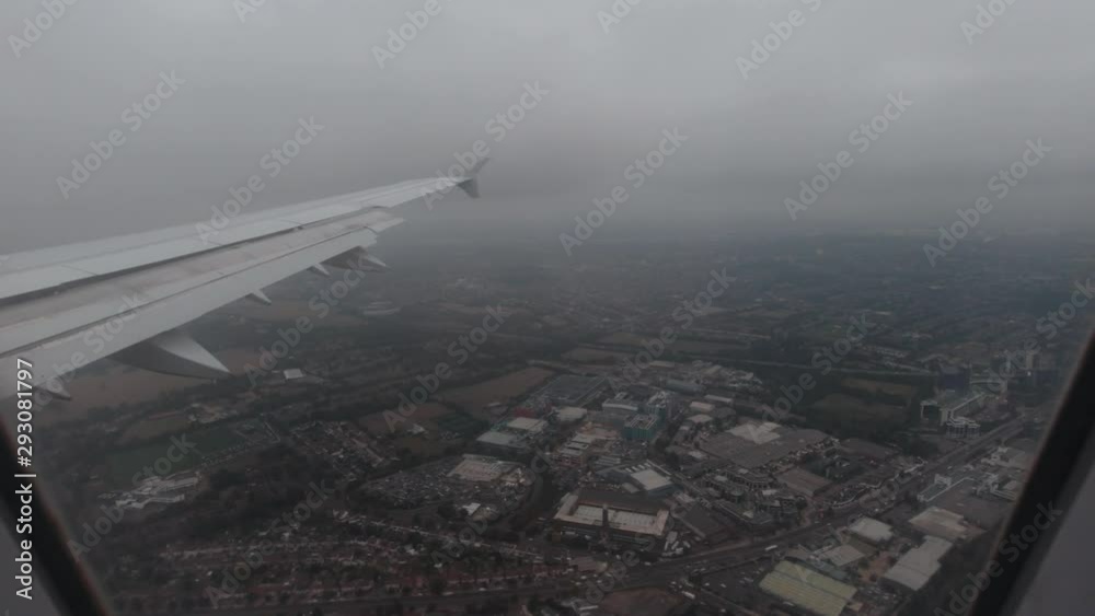 View out of a plane window over the United Kingdom in Slow Motion during a cloudy day View out of a plane window over the United Kingdom in Slow Motion during a cloudy day