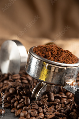 Coffee tamper,coffee press is made of stainless steel and roasted coffee beans from coffee roaster on black background,tool tamper