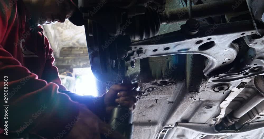 Portrait of a young beautiful car mechanic in a car service, in the background of rubber. Concept: repair of machines, fault diagnosis, repair specialist, technical maintenance and on-board computer. Portrait of a young beautiful car mechanic in a car service, in the background of rubber. Concept: repair of machines, fault diagnosis, repair specialist, technical maintenance and on-board computer.