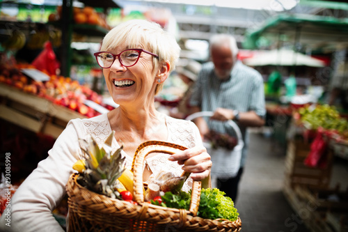 Canvas Print Mature woman buying vegetables at farmers market