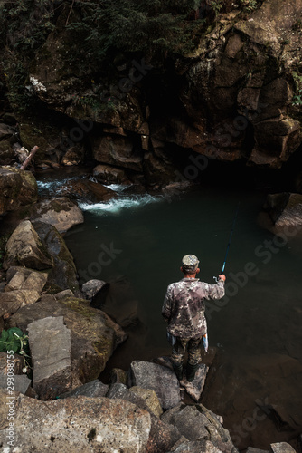 overhead view of military man fishing and standing on rock