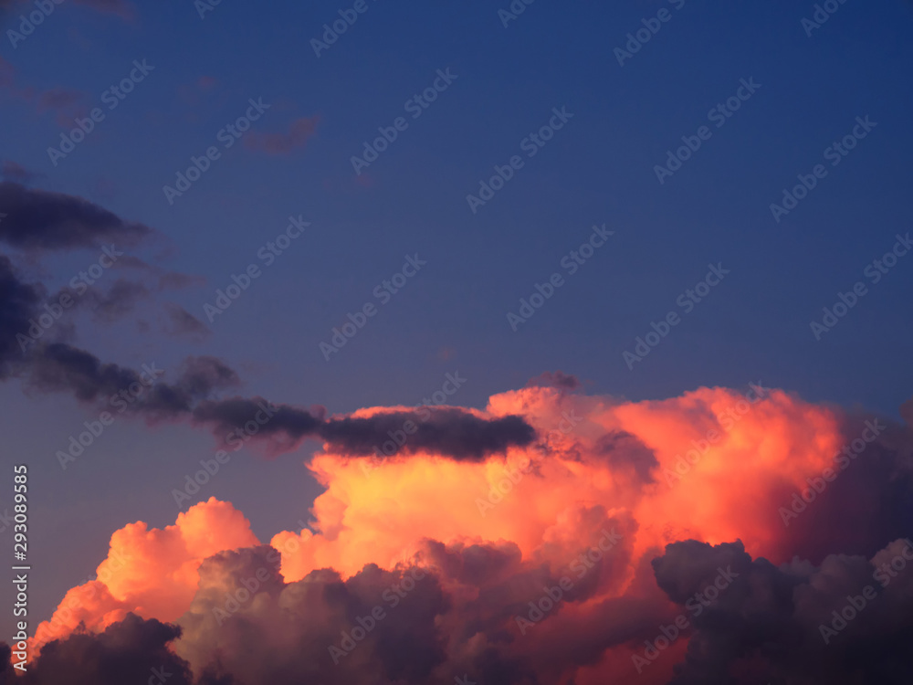 Thunderclouds on a sky background illuminated by the sun's rays of the setting sun