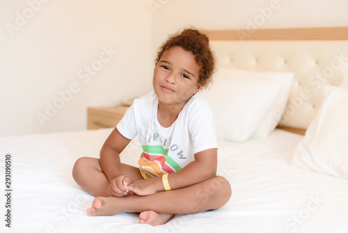 Cute little girl in pajamas on the bed in the morning.