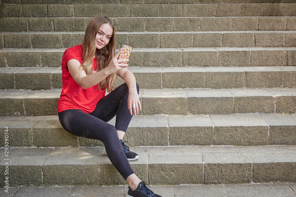 sports runner girl sitting on stairs resting, taking a selfie