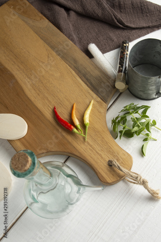Red Chili Peppers, orange and yellow on wooden cutting board.