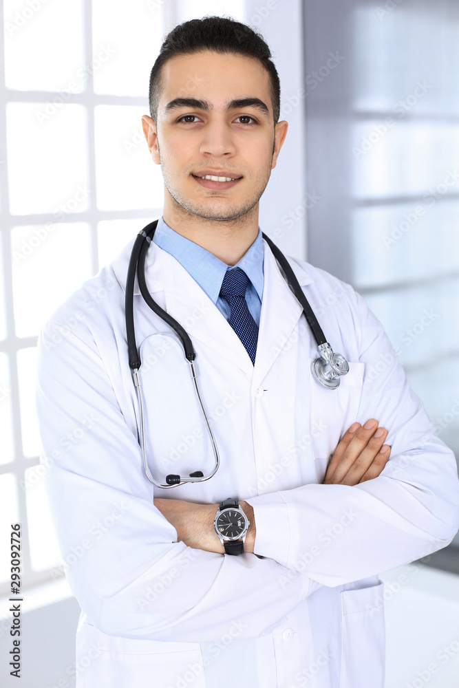 Arab doctor man standing with crossed arms in medical office or clinic. Medicine and healthcare concept Arab doctor man standing with crossed arms in medical office or clinic. Medicine and healthcare concept