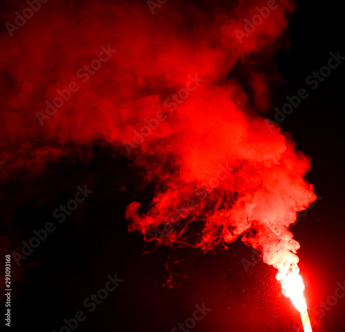 Red smoke burns at night as a background