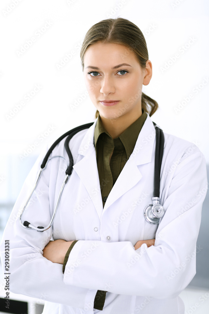 Doctor woman standing straight and looking at camera. Perfect medical service in clinic. Happy future in medicine and healthcare Doctor woman standing straight and looking at camera. Perfect medical service in clinic. Happy future in medicine and healthcare